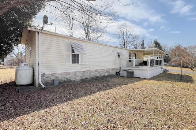 rear view of house with a lawn and central AC