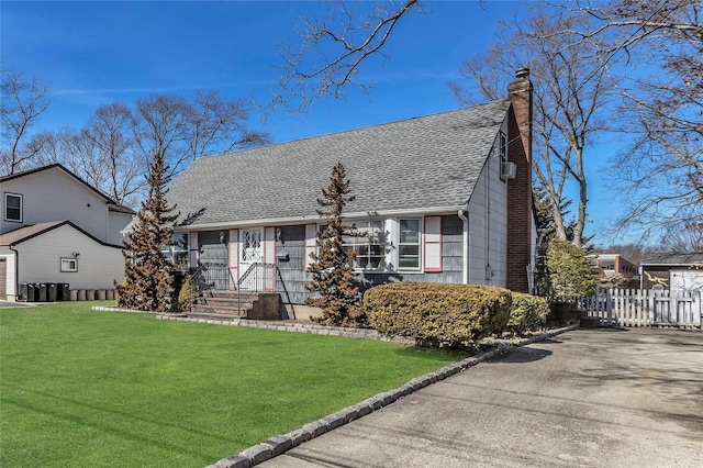 view of front of home featuring a shingled roof, fence, a front yard, a chimney, and driveway