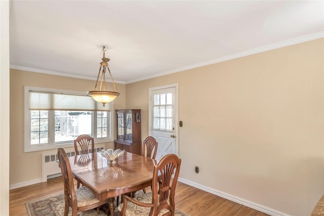 dining room with light wood-style flooring, baseboards, and ornamental molding