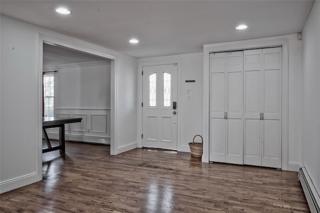 entrance foyer with dark wood-style floors, a decorative wall, recessed lighting, and a baseboard radiator