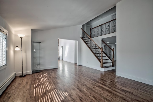 unfurnished living room featuring stairway, wood finished floors, baseboards, high vaulted ceiling, and a baseboard heating unit