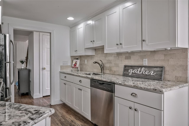 kitchen with dark wood finished floors, a sink, stainless steel appliances, white cabinets, and tasteful backsplash