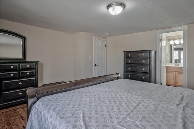 bedroom featuring ensuite bath and wood finished floors