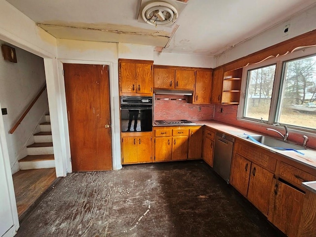 kitchen featuring a sink, open shelves, appliances with stainless steel finishes, brown cabinetry, and light countertops