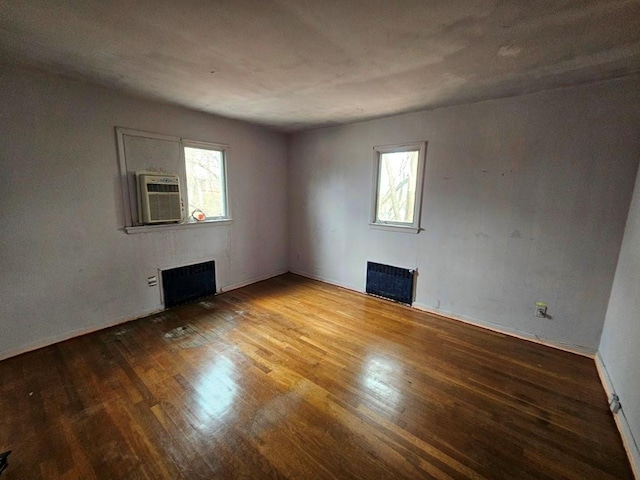 unfurnished room featuring plenty of natural light, wood finished floors, and a fireplace