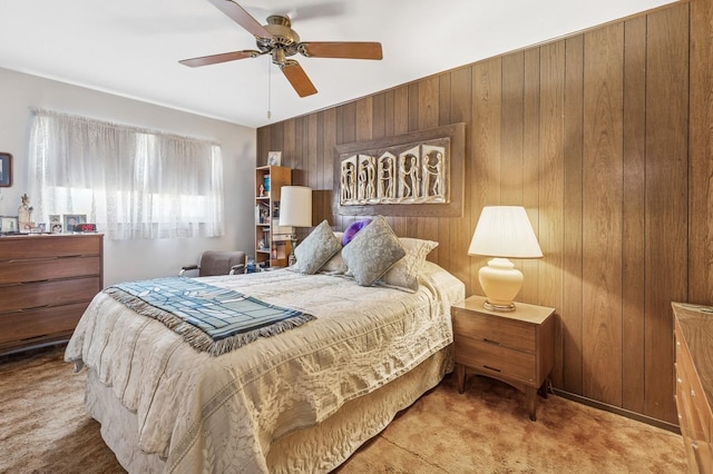 bedroom with carpet flooring, a ceiling fan, and wood walls