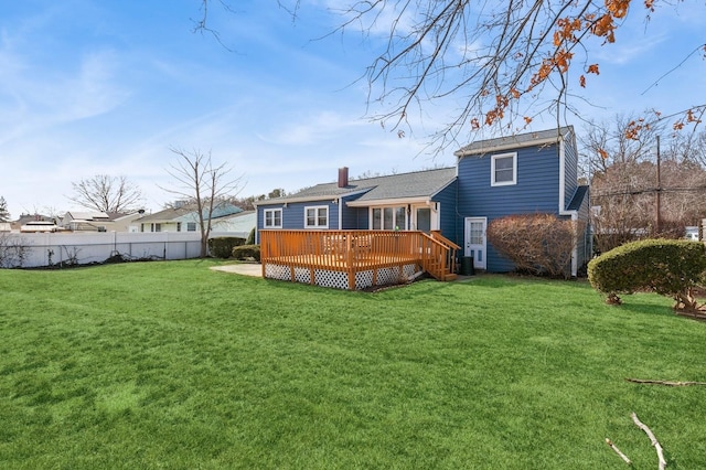 back of house featuring a deck, a yard, fence, and a chimney