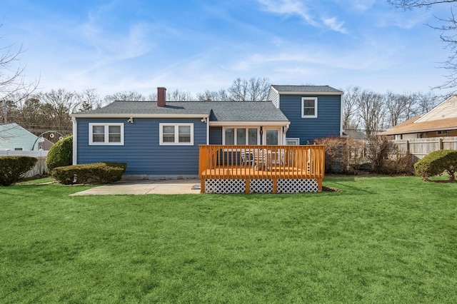 back of property with a wooden deck, a yard, fence, and a chimney