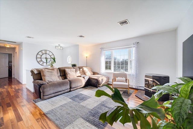 living area featuring wood finished floors, visible vents, and baseboards