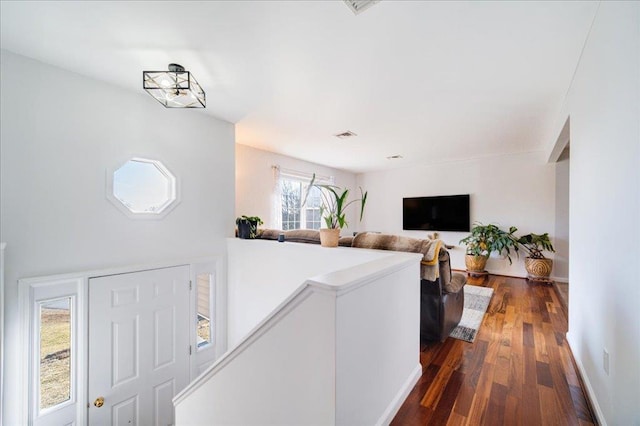 foyer featuring dark wood-type flooring and baseboards