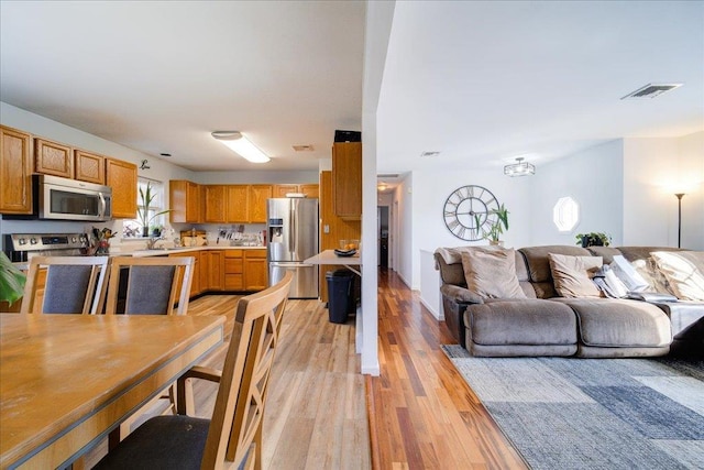 dining area featuring visible vents and light wood-style floors