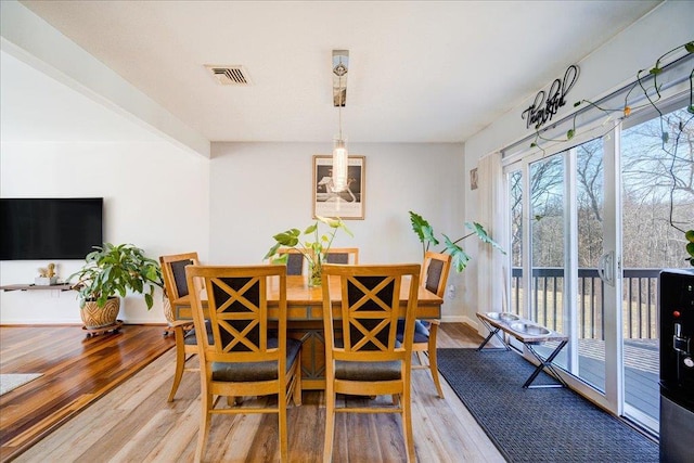 dining room featuring visible vents, baseboards, and wood finished floors