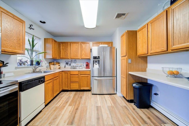 kitchen with visible vents, light wood-type flooring, light countertops, stainless steel appliances, and a sink