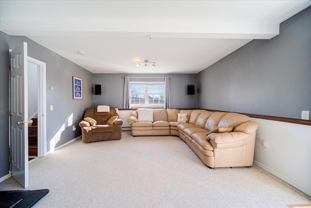 living area with beam ceiling, baseboards, and carpet floors