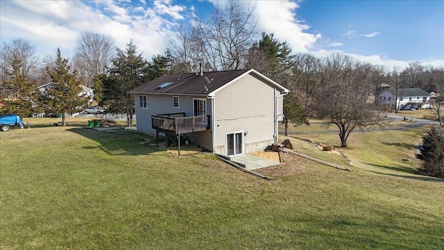 back of property featuring a lawn and a wooden deck