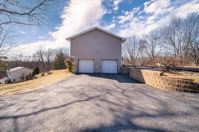 view of home's exterior featuring an attached garage and driveway