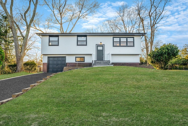 split foyer home with a front yard, an attached garage, and driveway