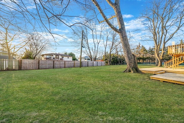 view of yard with a deck and fence