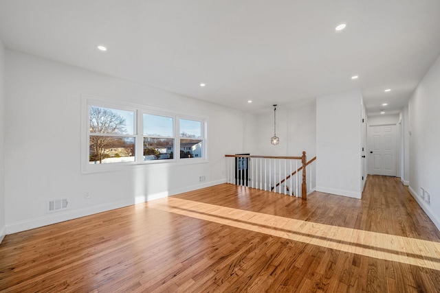 spare room with recessed lighting, visible vents, baseboards, and wood finished floors