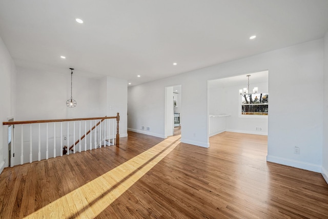 spare room with visible vents, baseboards, a chandelier, recessed lighting, and wood finished floors