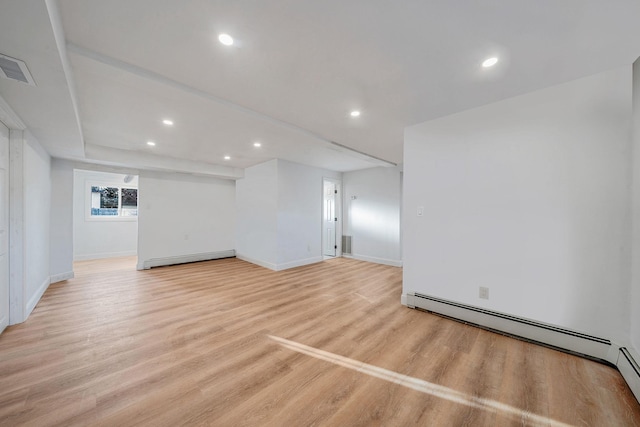 empty room with recessed lighting, baseboard heating, light wood-style flooring, and visible vents