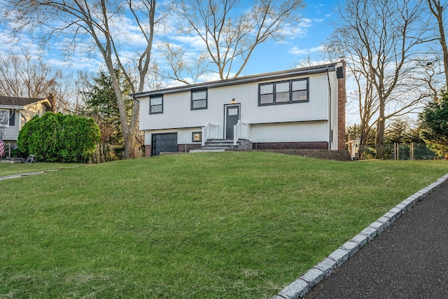 split foyer home with driveway, fence, an attached garage, a front yard, and a chimney