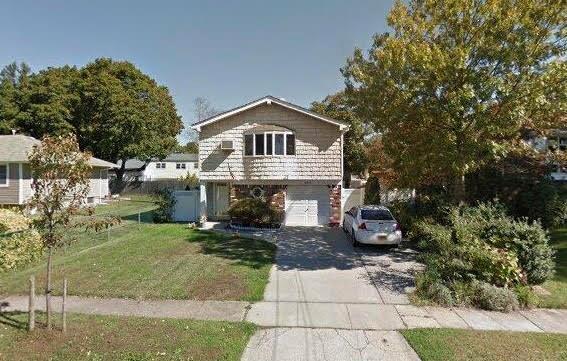 view of front of property with driveway, an attached garage, and a front yard