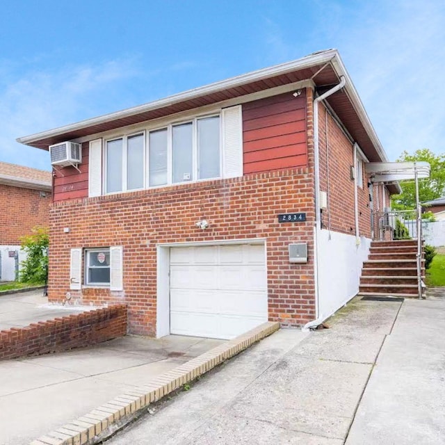 28-34 Corporal Kennedy St, Flushing, NY 11360 - view of front of house featuring brick siding, a garage, and concrete driveway