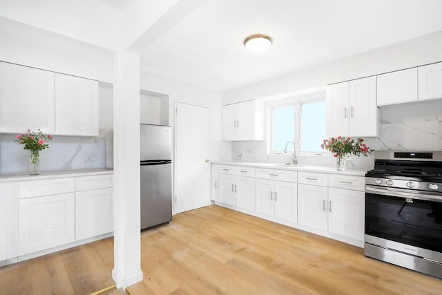 28-34 Corporal Kennedy St, Flushing, NY 11360 - kitchen with stainless steel appliances, light countertops, white cabinetry, and a sink