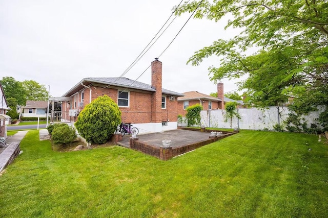 28-34 Corporal Kennedy St, Flushing, NY 11360 - rear view of house featuring brick siding, a chimney, and a patio area