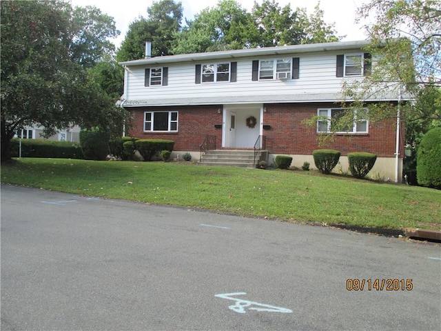 view of front of house featuring brick siding and a front lawn