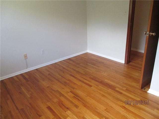 empty room featuring baseboards and wood finished floors