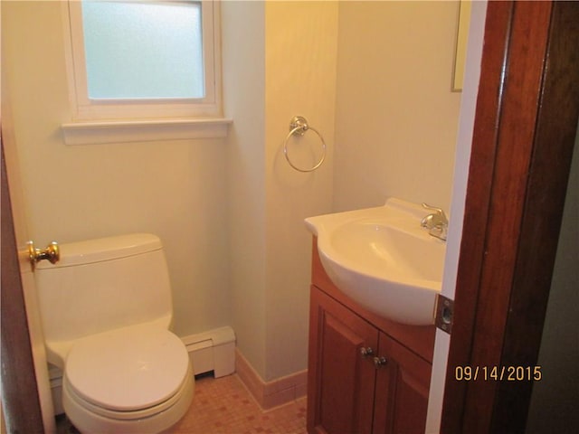 half bathroom featuring vanity, toilet, baseboards, and baseboard heating