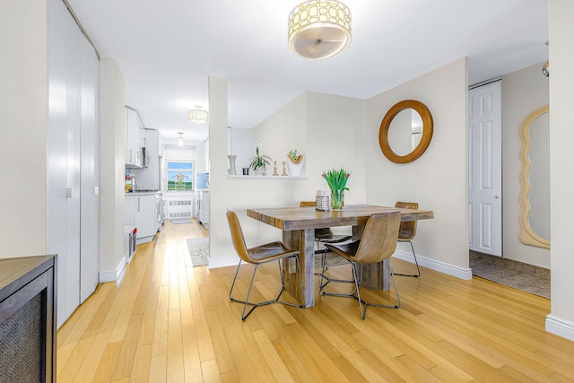 dining space featuring baseboards and light wood-style floors