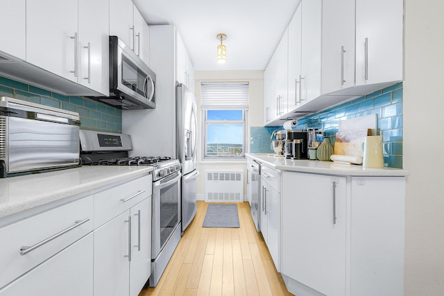 kitchen with white cabinetry, light countertops, tasteful backsplash, and appliances with stainless steel finishes