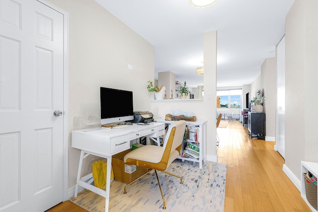 office featuring baseboards and light wood-style floors