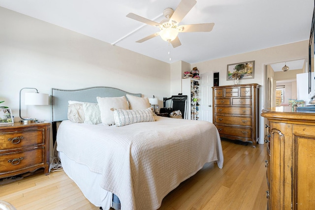 bedroom featuring a ceiling fan, a closet, and light wood finished floors