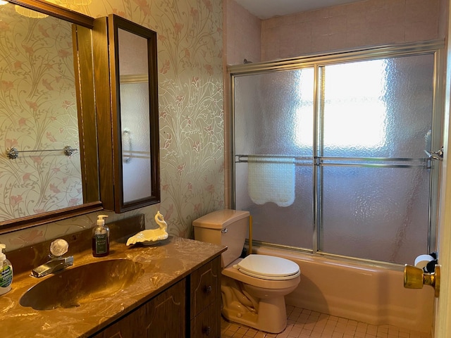 full bath featuring vanity, wallpapered walls, tile patterned flooring, toilet, and combined bath / shower with glass door