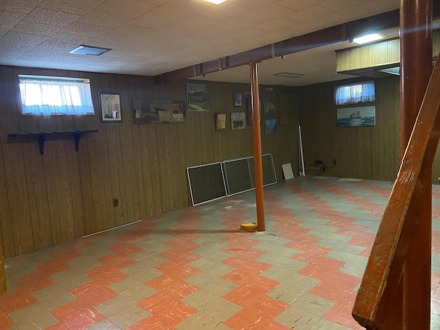 basement with tile patterned floors and wooden walls