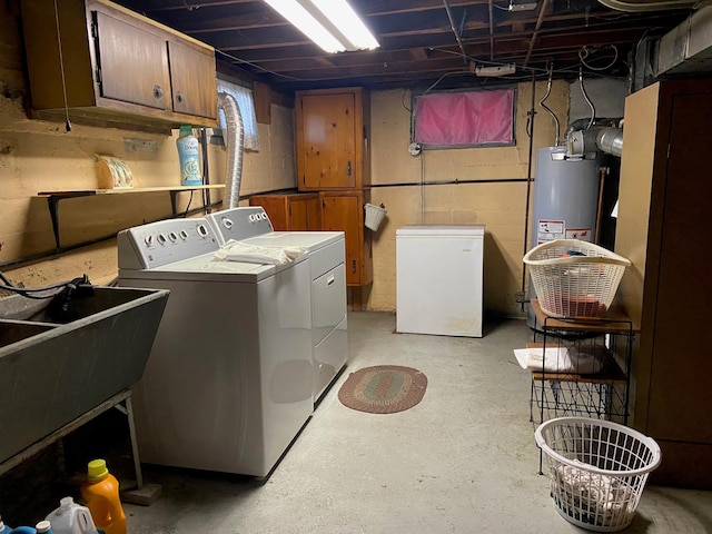 washroom with a sink, cabinet space, water heater, and washing machine and clothes dryer