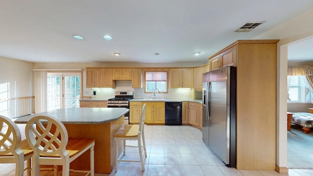 kitchen featuring light brown cabinets, visible vents, appliances with stainless steel finishes, and a sink