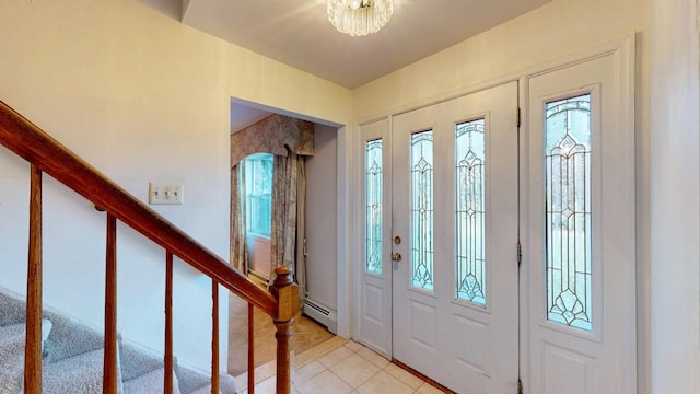 entryway with light tile patterned floors, stairway, and a baseboard heating unit