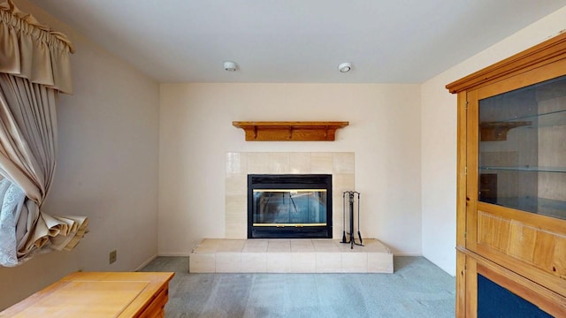 unfurnished living room featuring baseboards, carpet, and a tile fireplace