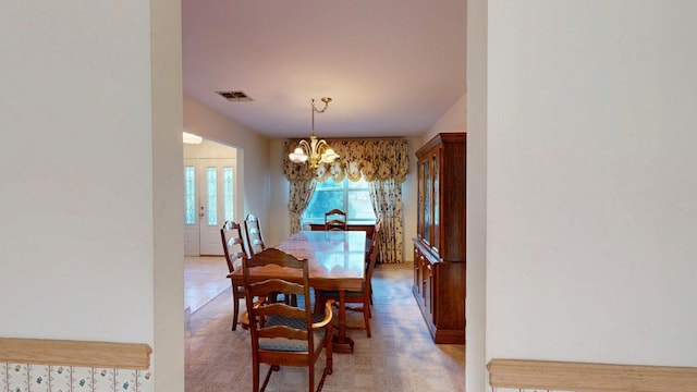 dining space featuring a chandelier and visible vents