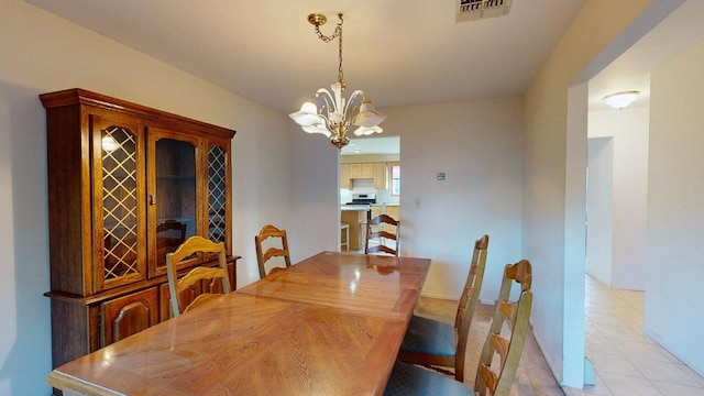 dining area featuring light tile patterned floors, visible vents, and a notable chandelier