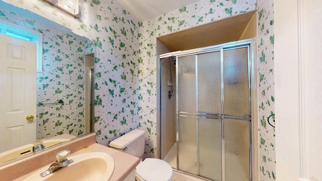 full bath with a shower stall, wallpapered walls, vanity, and toilet