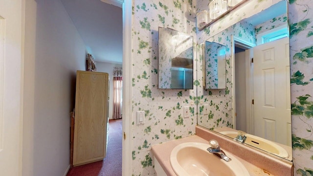 bathroom with a sink and wallpapered walls