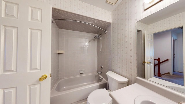 bathroom featuring vanity, toilet, shower / tub combination, and wallpapered walls