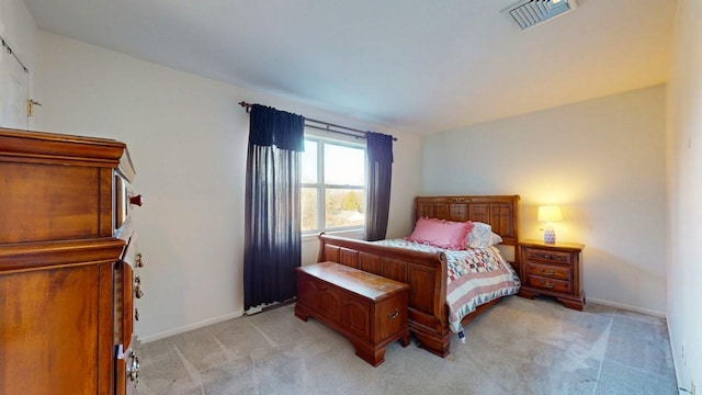 bedroom featuring baseboards, visible vents, and light carpet