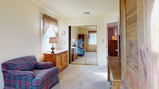 living area with visible vents, light colored carpet, and a baseboard radiator